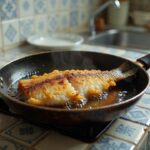 Peixe sendo frito crocante em frigideira sem odor e respingos de óleo
