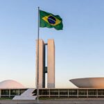 Palácio do Congresso Nacional em Brasília com bandeira brasileira, cenário político para candidatura ao Senado.