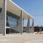 Fachada de tribunal de justiça brasileiro com canteiro de obras ao fundo