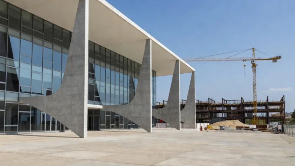 Fachada de tribunal de justiça brasileiro com canteiro de obras ao fundo