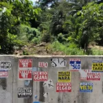 Adesivos de campanha política em parede urbana de Porto Velho