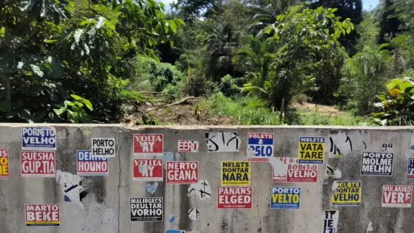 Adesivos de campanha política em parede urbana de Porto Velho